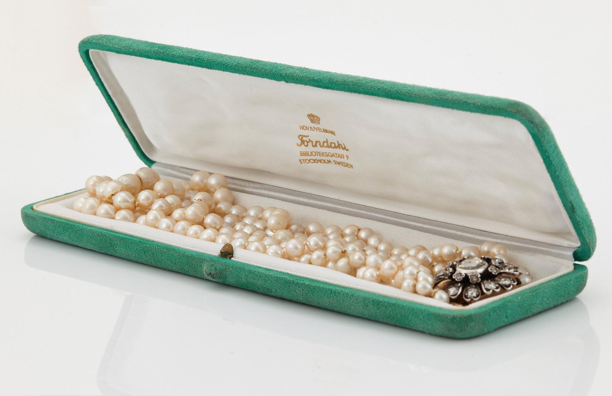 A three strand cultured pearl necklace with a clasp in 18K gold and silver set with rose- and old-cut diamonds.