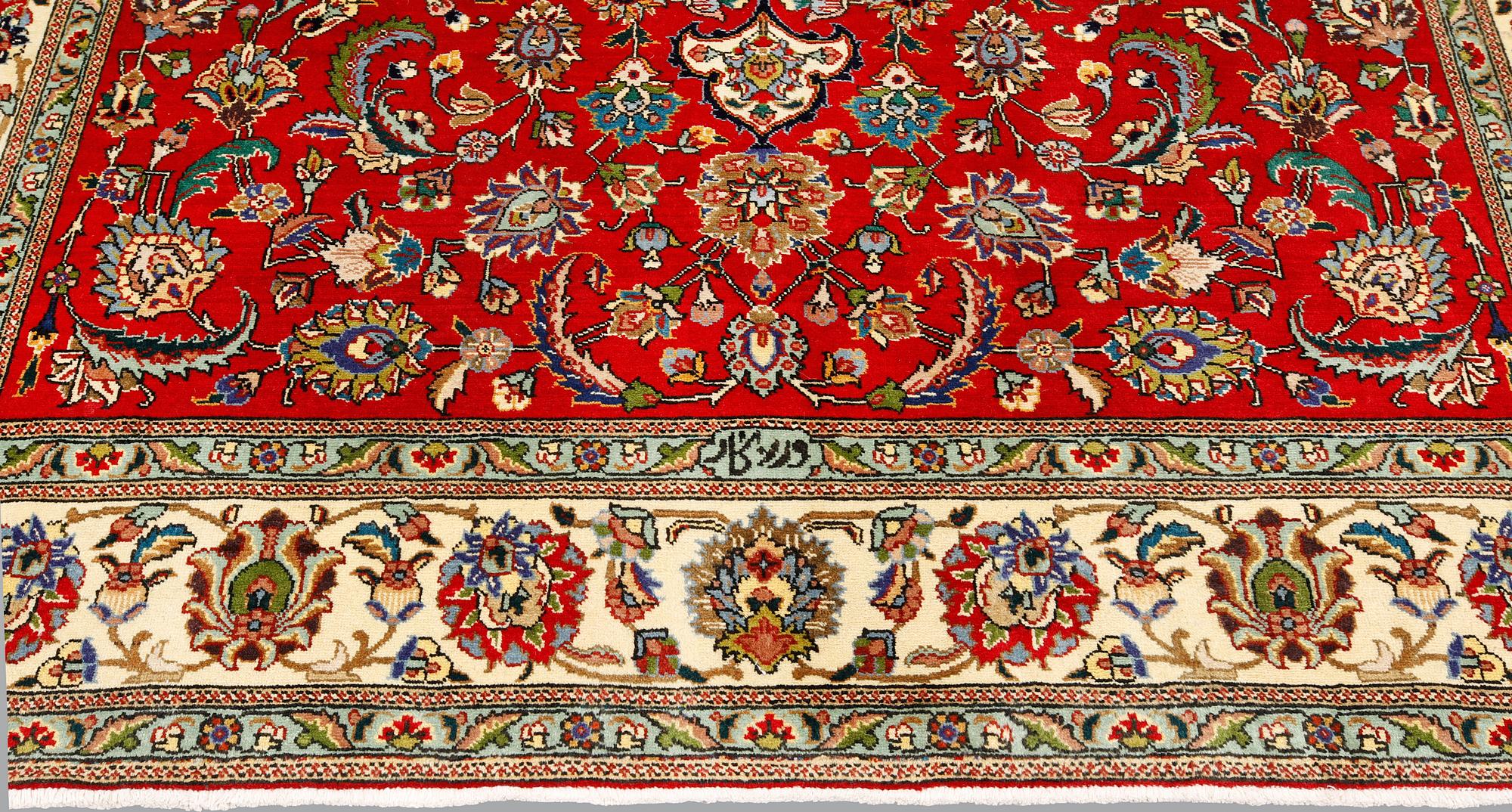 A signed Tabriz carpet, ca 336 x 223 cm.