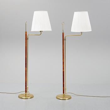 A pair of brass and leather floor lights.