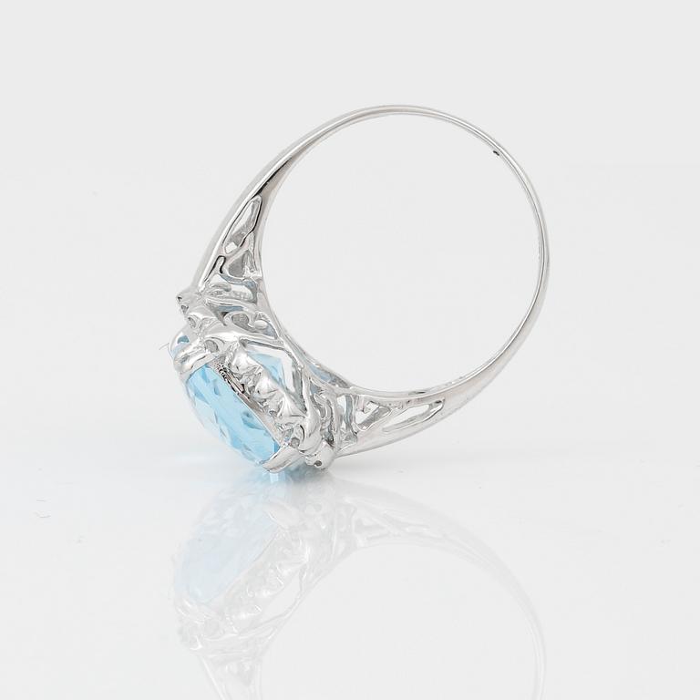 RING, 18K vitguld med chequerslipad blå topas, ca 5,23 ct, diamanter tot ca 0,20 ct. Vikt ca 4,17 g.