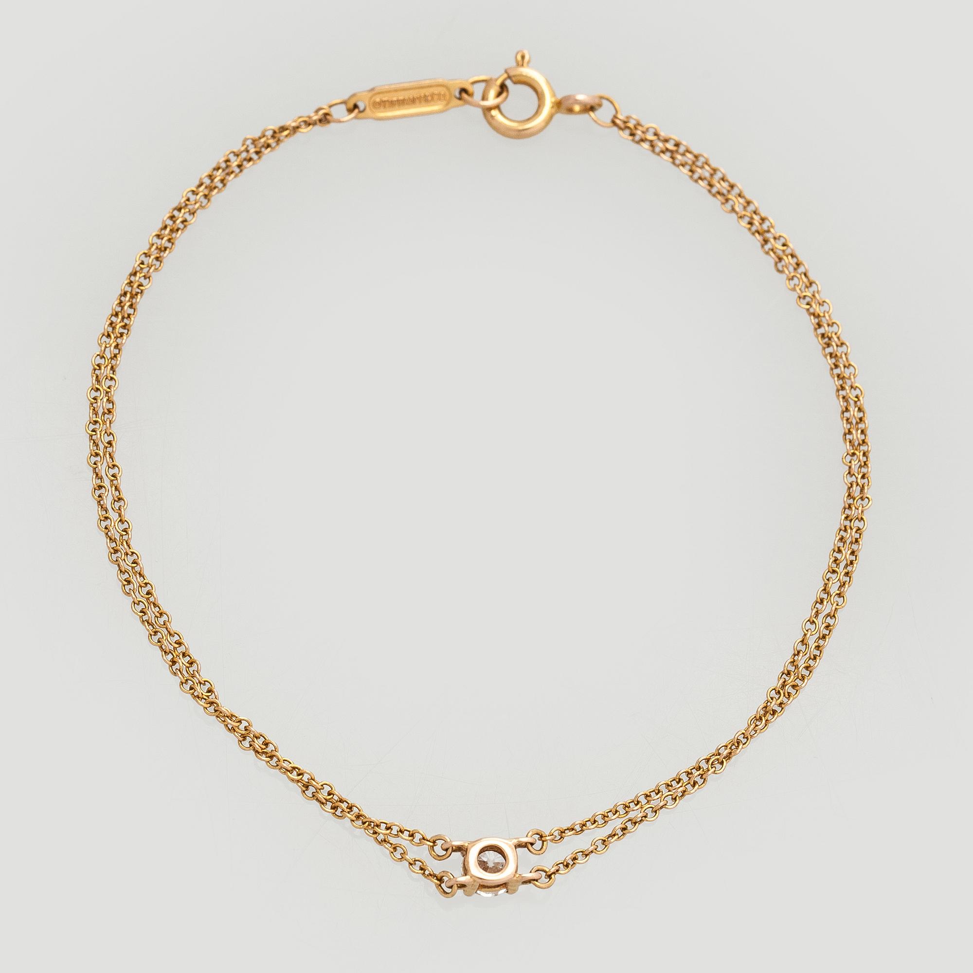 Tiffany & Co, armband, 18K guld med en briljantslipad diamant.