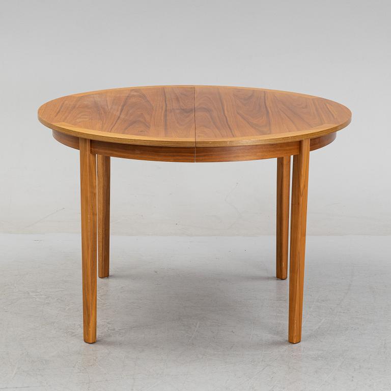 A round walnut veneered dining table.