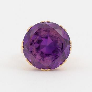 A ring set with a synthetic, purple sapphire.