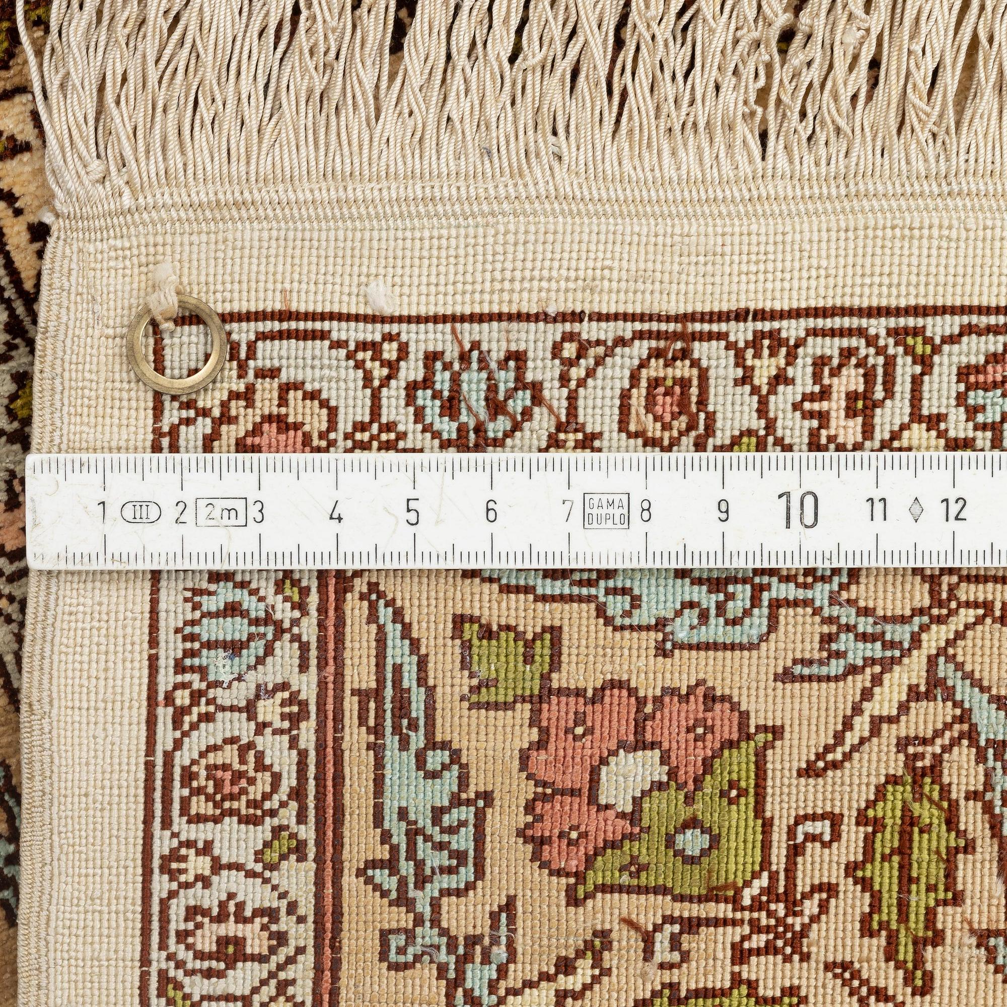 A silk Hereke rug, c. 112 x 74 cm.