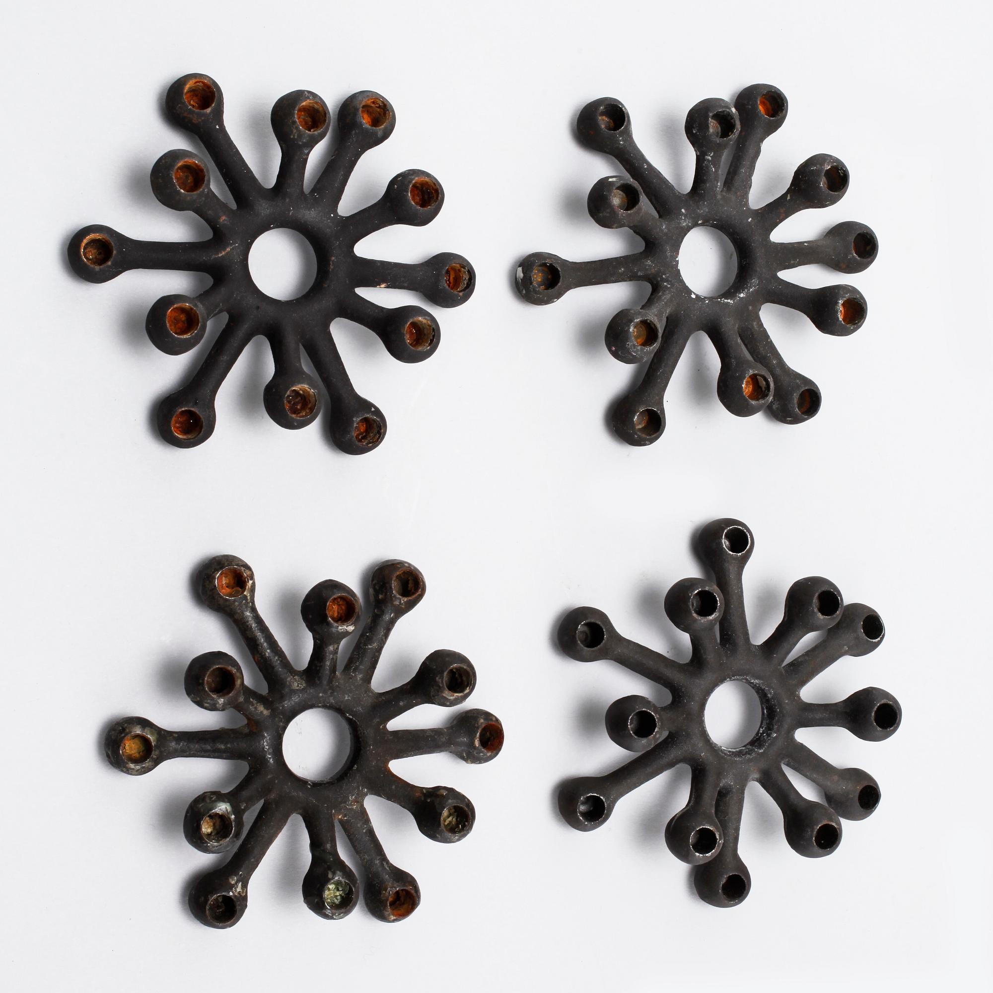 Four 1960s iron cast candle holders, designed by Jens Quistgaard for Dansk Designs .