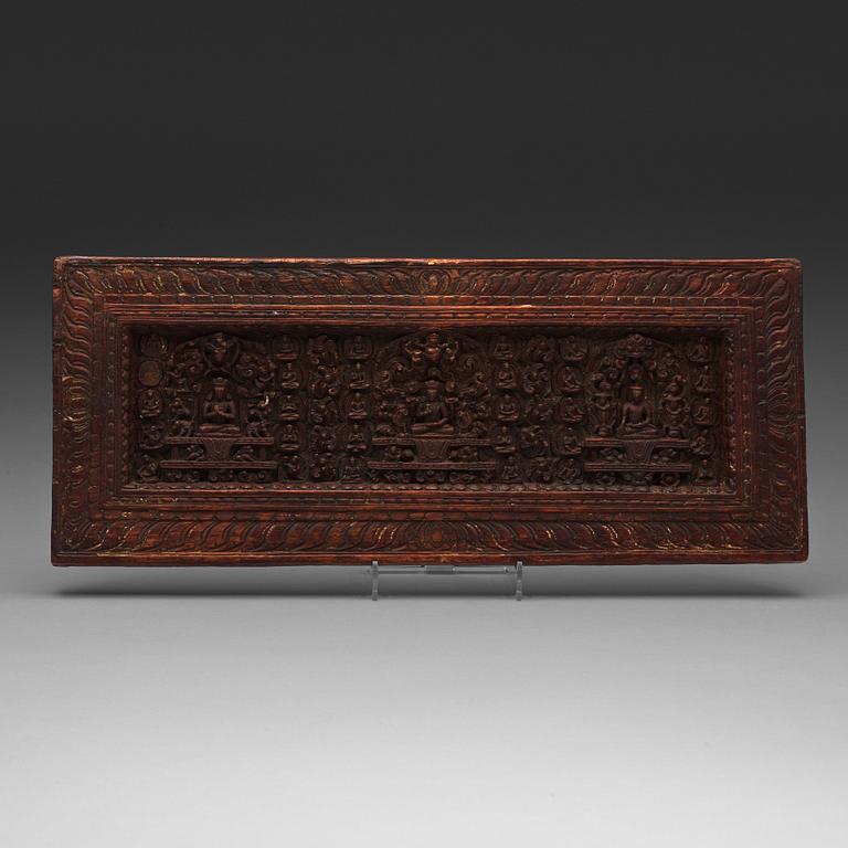 A large carved wooden sutra-board, Tibet, presumably 15th century.