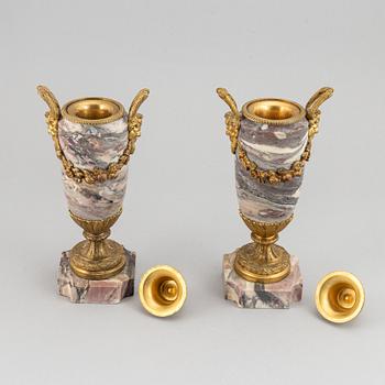 A pair of marble urns with bronze mountings from around year 1900.