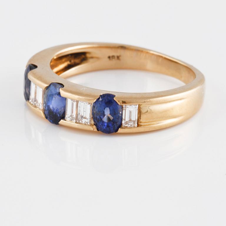 RING, 18K guld med baguetteslipade diamanter samt 3 ovalslipade blå safirer. Vikt 5,2 gram.