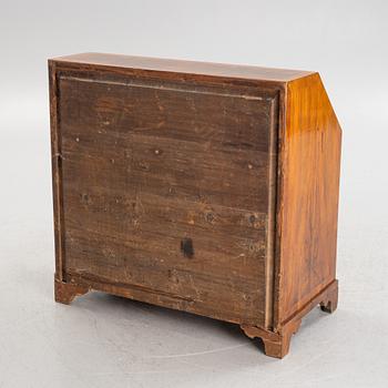 A rococo walnut-veneered and gilt-brass mounted secretaire, later part of the 18th century.