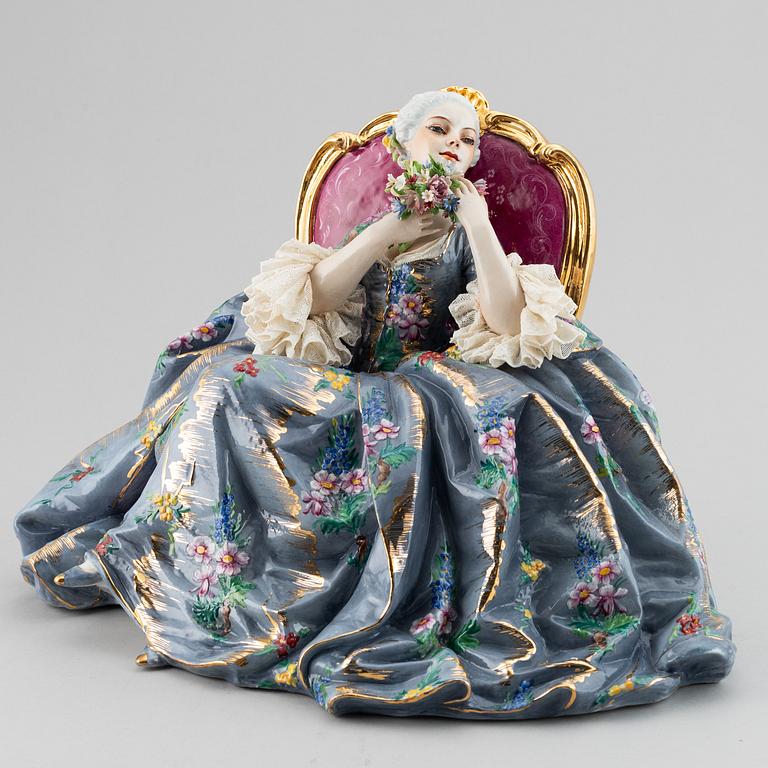 A porcelain figurine of a seated Rococo lady, 20th century, Italy.