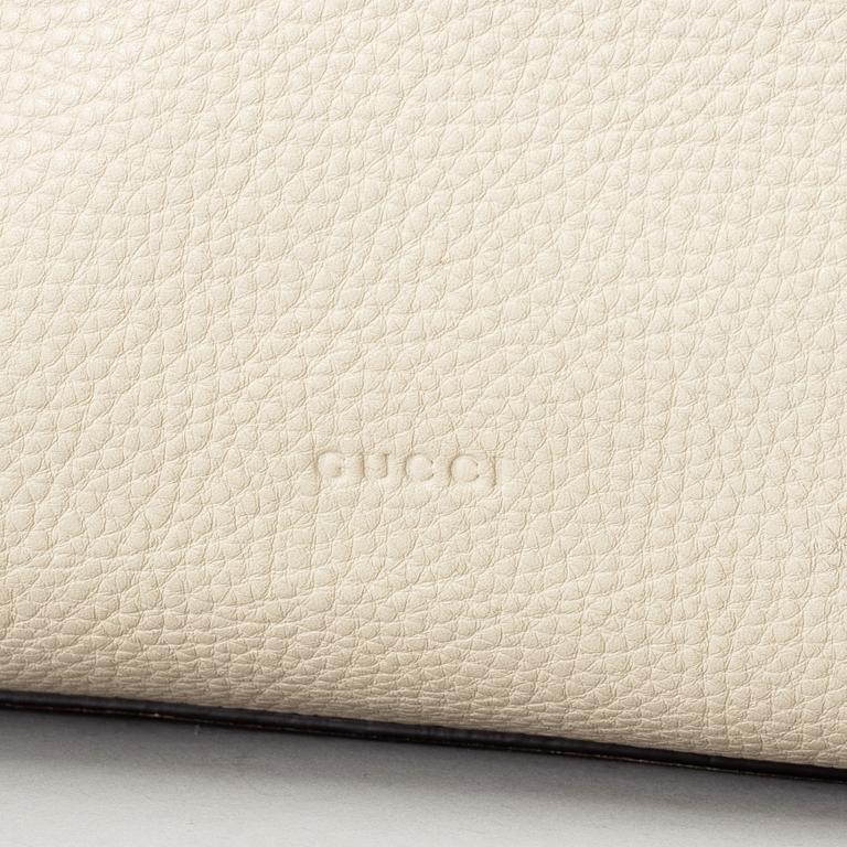 GUCCI, a white leather tote bag with bamboo handles.