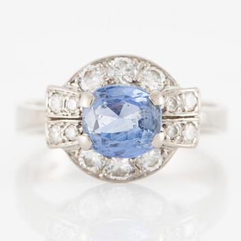 Ring 18K white gold set with a faceted sapphire and round brilliant-cut diamonds.