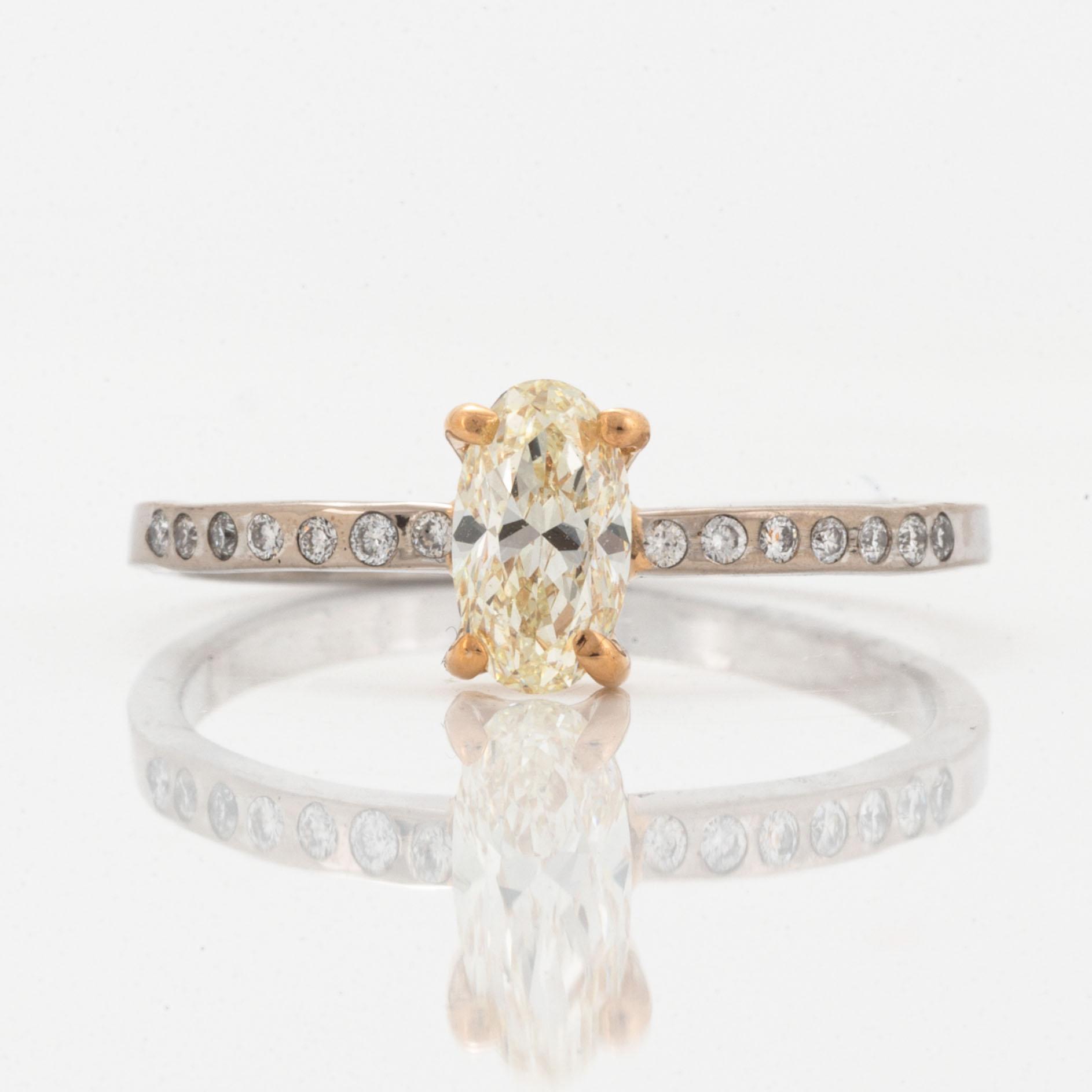 Oval diamond and brilliant-cut diamond ring.