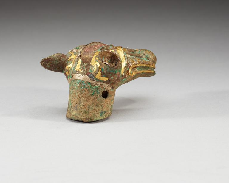 An archaistic bronze handle for a cane in the shape of a mythological animal.