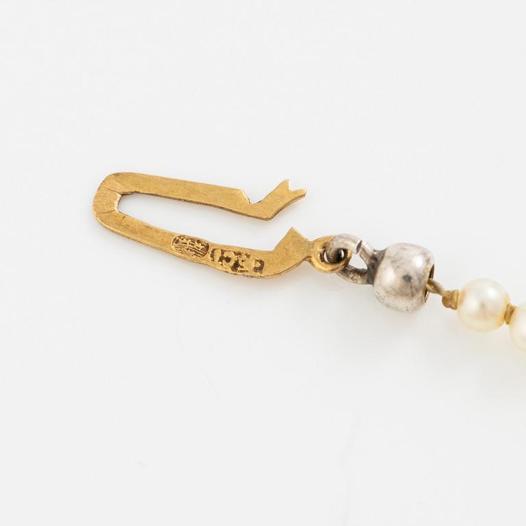 Necklace of cultured pearls with a clasp in 18K gold set with a blue stone.
