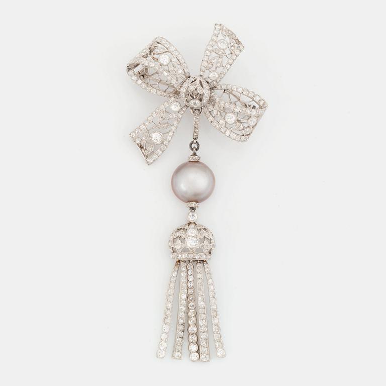 A platinum bow brooch set with old-cut diamonds with a detachable pearl and platinum pendant.