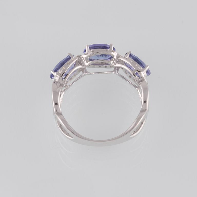RING, 18K vitguld med briljantslipade diamanter ca 0.35 ct samt 3 ovalslipade tanzaniter ca 2.11 ct. Vikt 3,6 gram.
