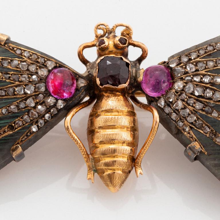 A butterfly brooch in 14K gold set with labradorite, rubies, rose-cut diamonds and garnets.