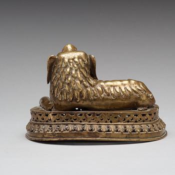 A copper alloy figure of a reclining buddhist lion, presumably 18th Century.