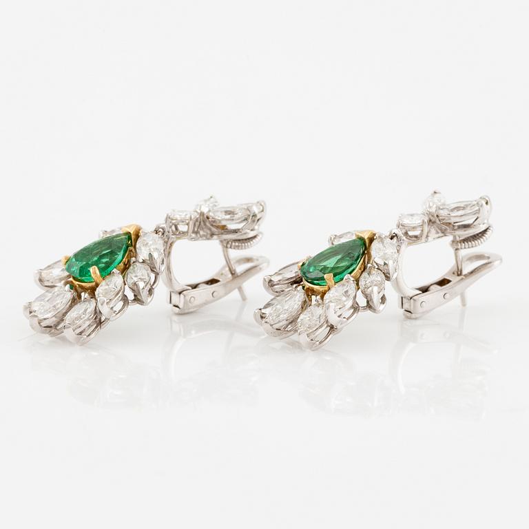 A pair of earrings in 18K white gold with drop-shaped faceted emeralds and diamonds.