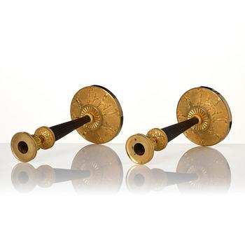 A pair of Empire ormolu and patinated bronze candlesticks.