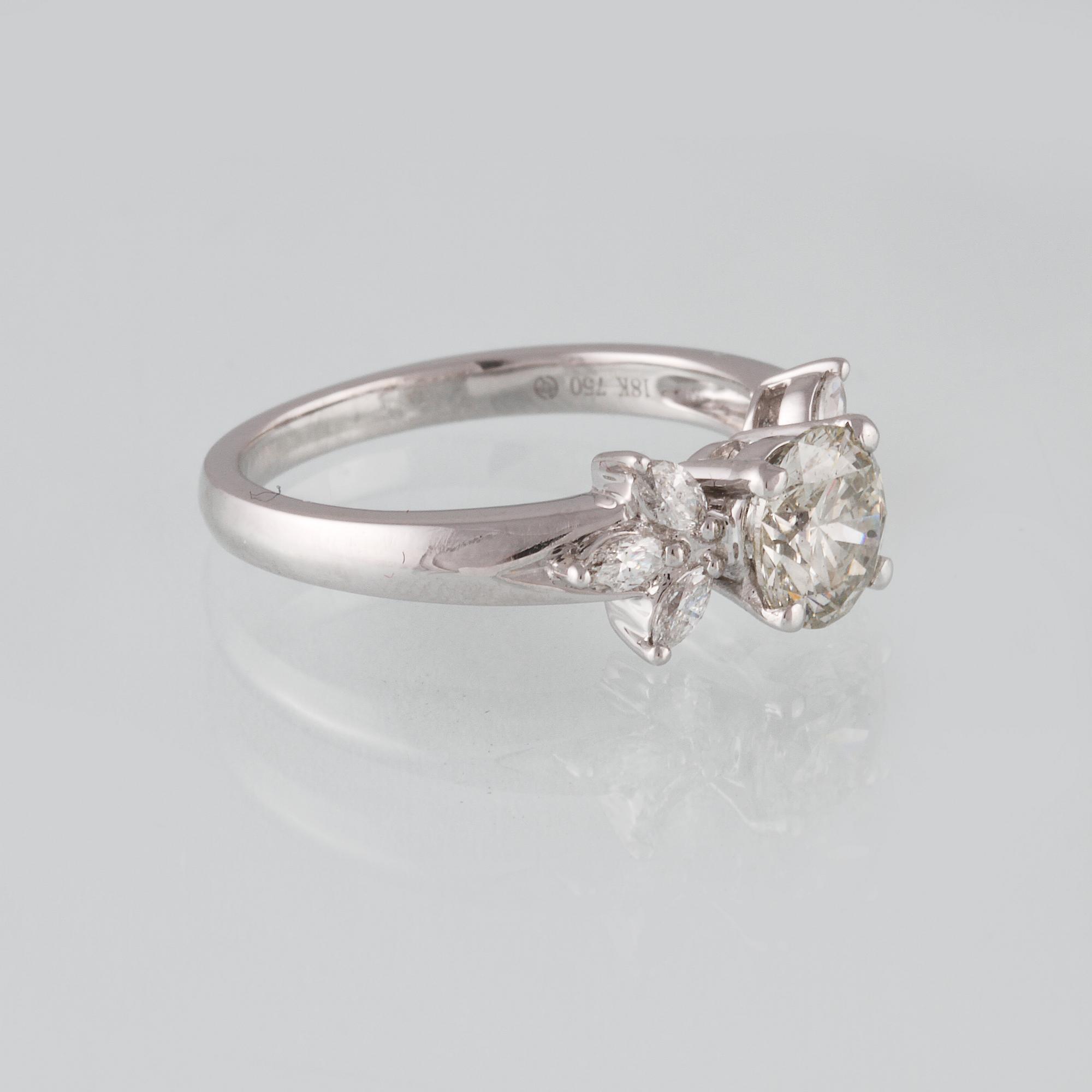 RING, 18K vitguld med briljantslipad diamant ca 1.11 ct samt 6 navetteslipade diamanter 0.26 ct. Vikt 4,2 gram.