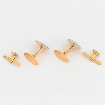 A pair of cufflinks and a pair of shirt buttons.