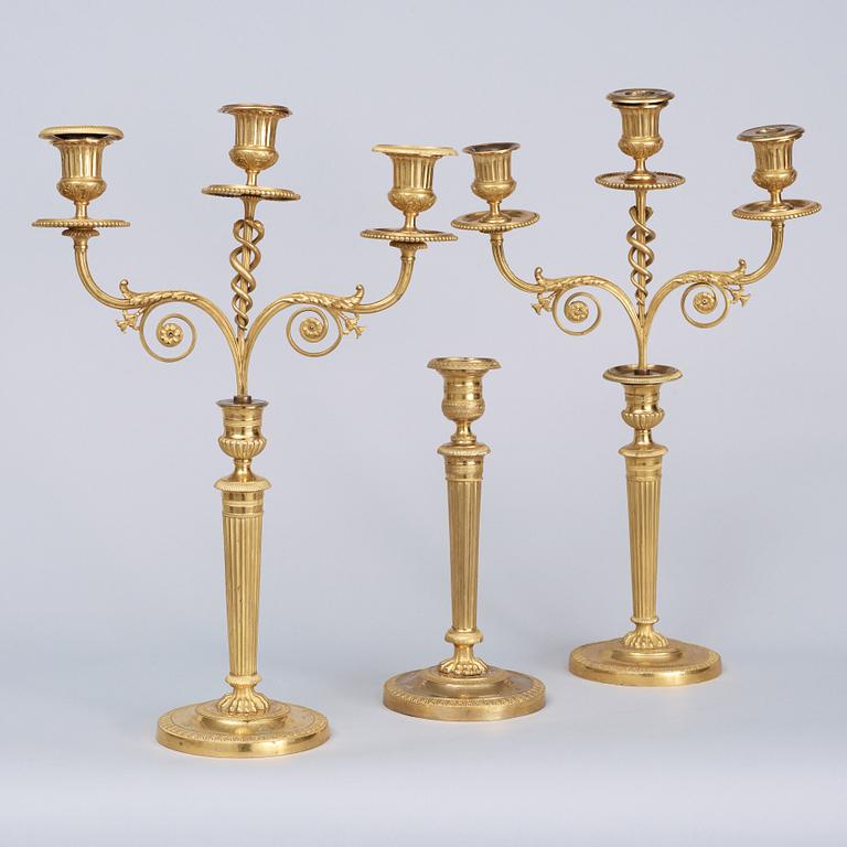 A matched pair Empire early 19th century gilt bronze candelabra/candlesticks. Including one empire candlestick.