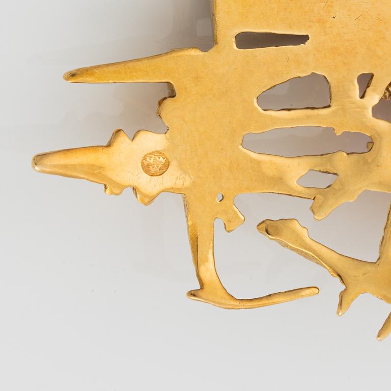 An 18K gold brooch set with faceted rubies.