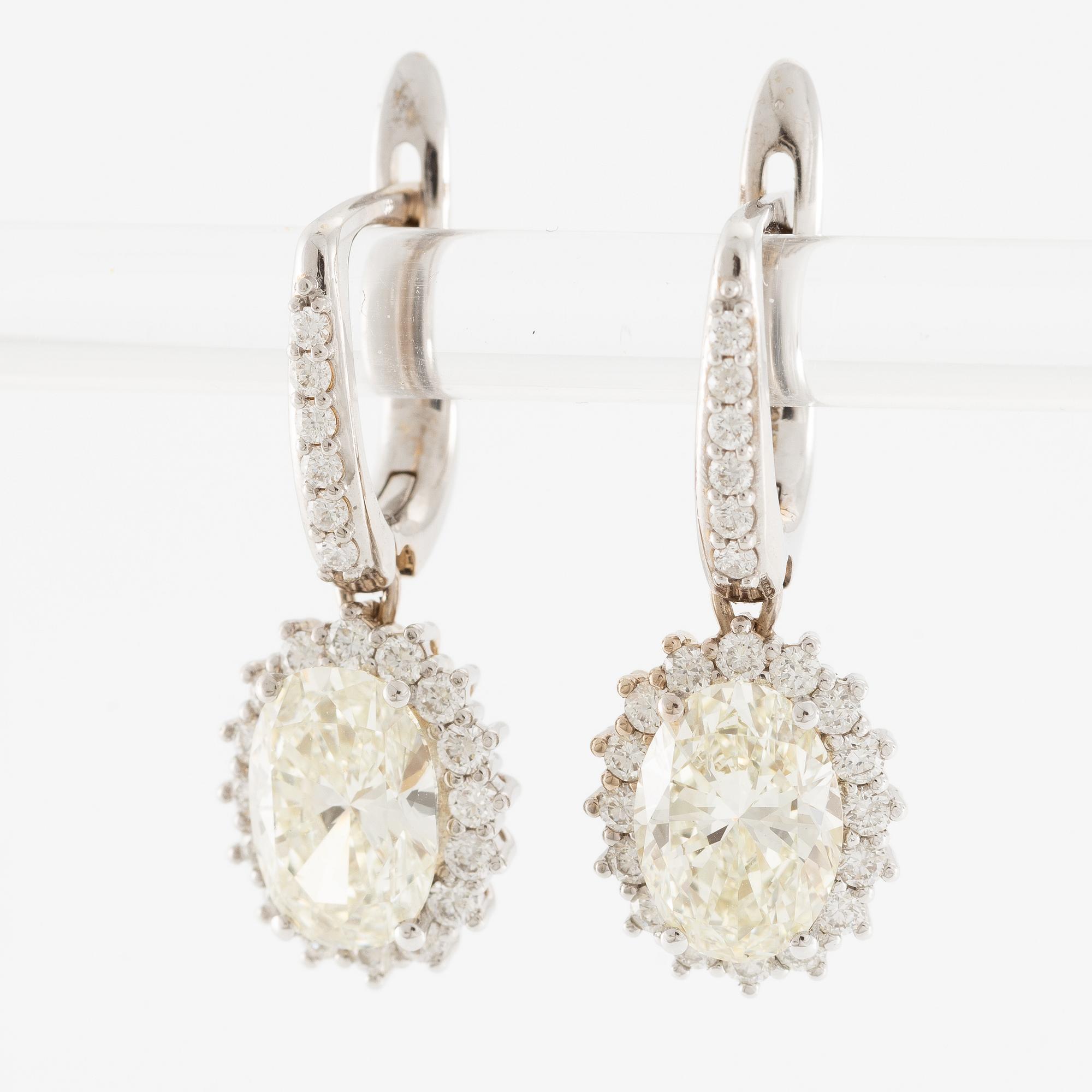 Earrings 18K white gold set with oval-cut diamonds, accompanied by GIA report.