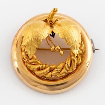 An 18K gold brooch.