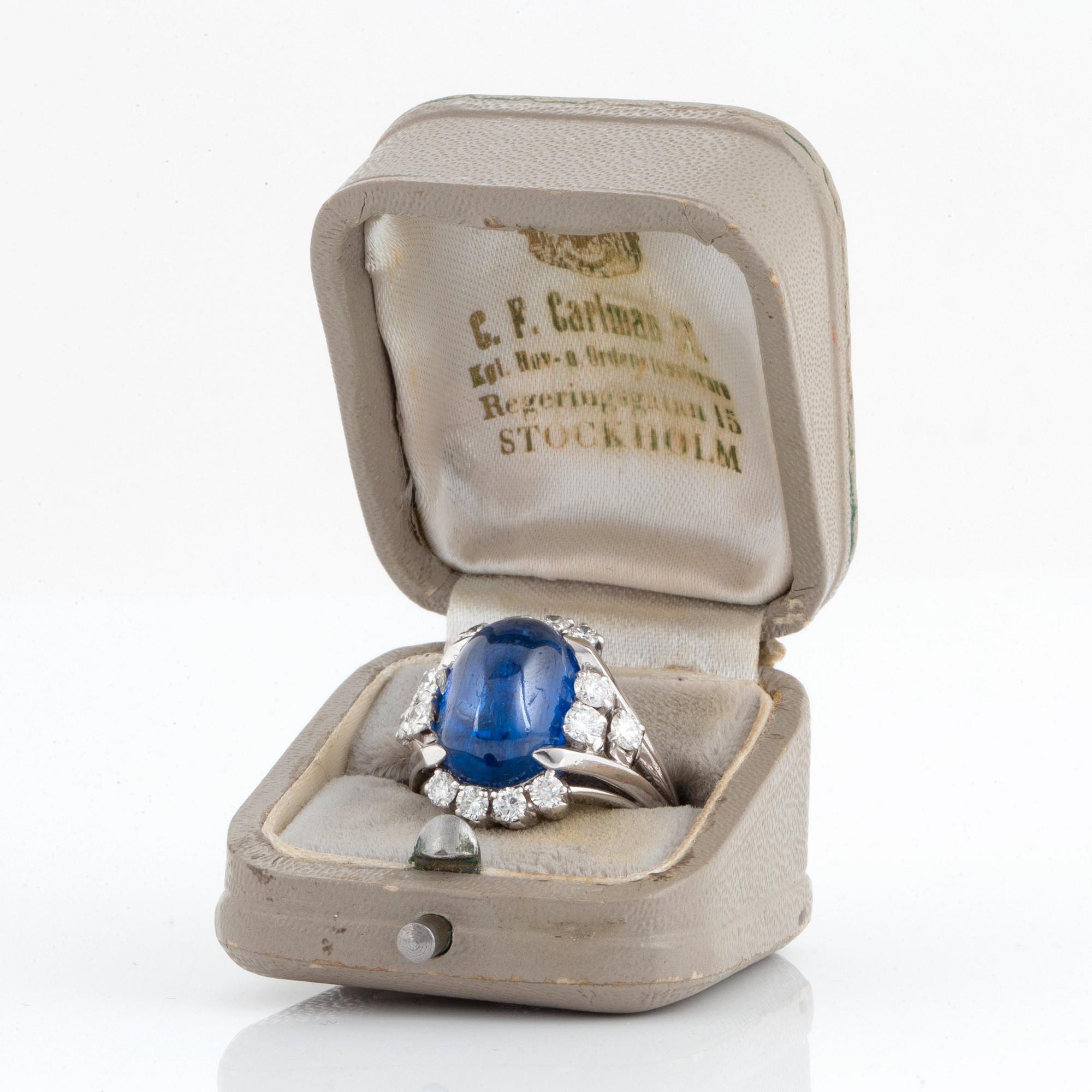 Ring 18K vitguld med en cabochonslipad safir ca 11.00 ct samt runda briljantslipade diamanter.