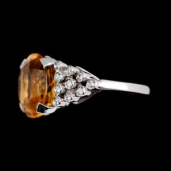 RING, 18 k vitguld, oval fasettslipad citrin ca 7.00 ct, 20 briljantslipade diamanter tot ca 0.20 ct.