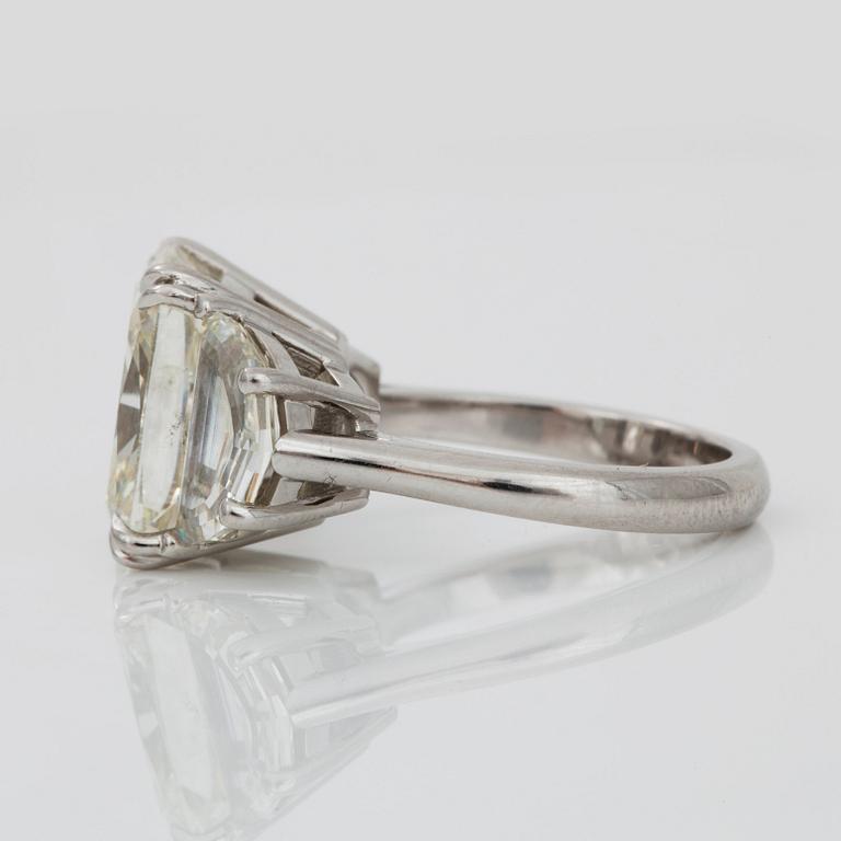 A cushion-cut diamond ring. Center diamond 8.08 ct. Quality circa L-M/SI1. Epaulette-cut side stones 2.63cts in total.