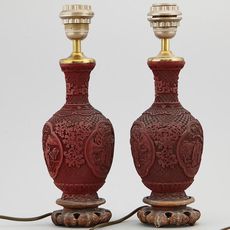 A pair of Chinese red lacquered vases, turned into table lamps, 20th century.