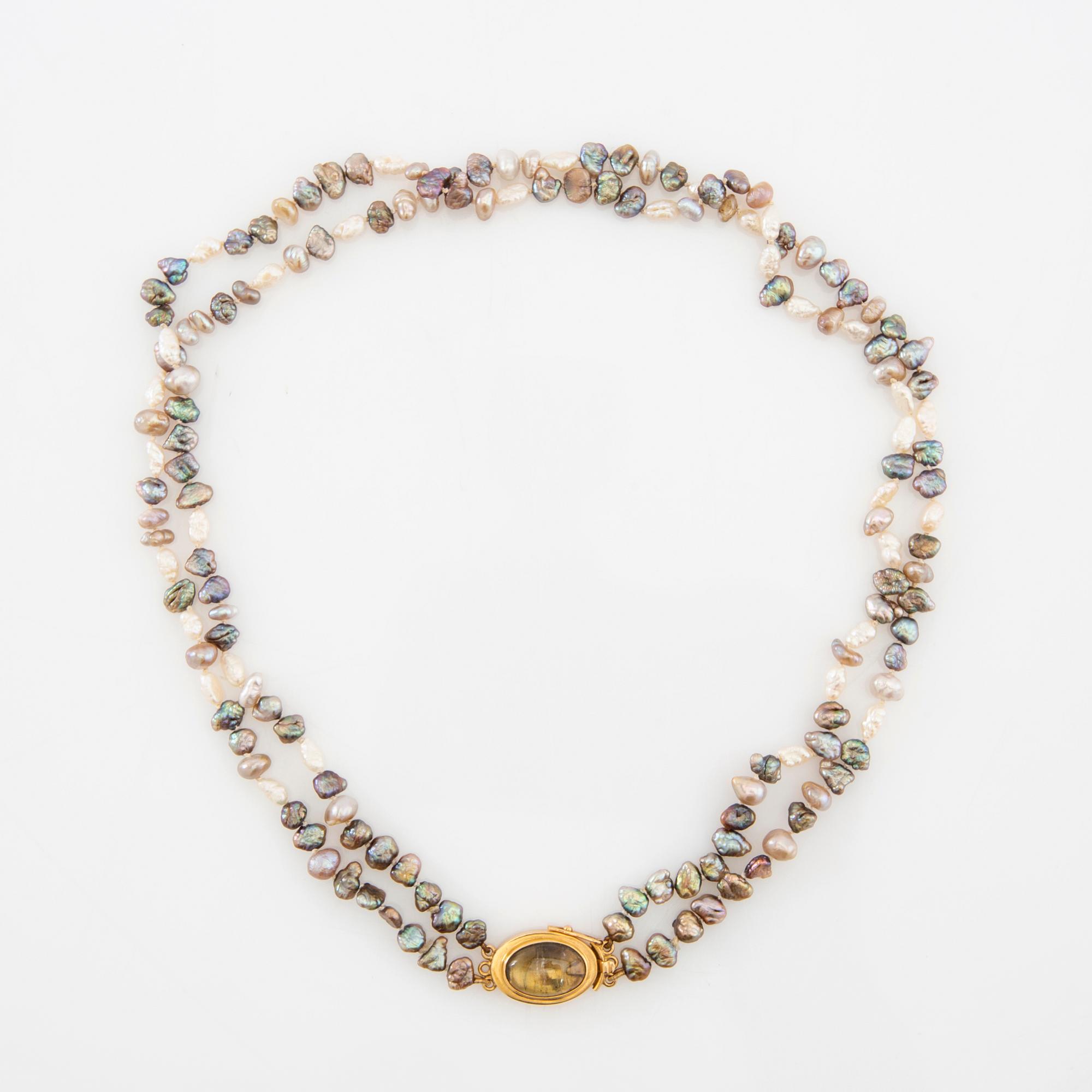 Necklace of cultured pearls with a clasp of 18K gold and cabochon-cut likely tourmaline.