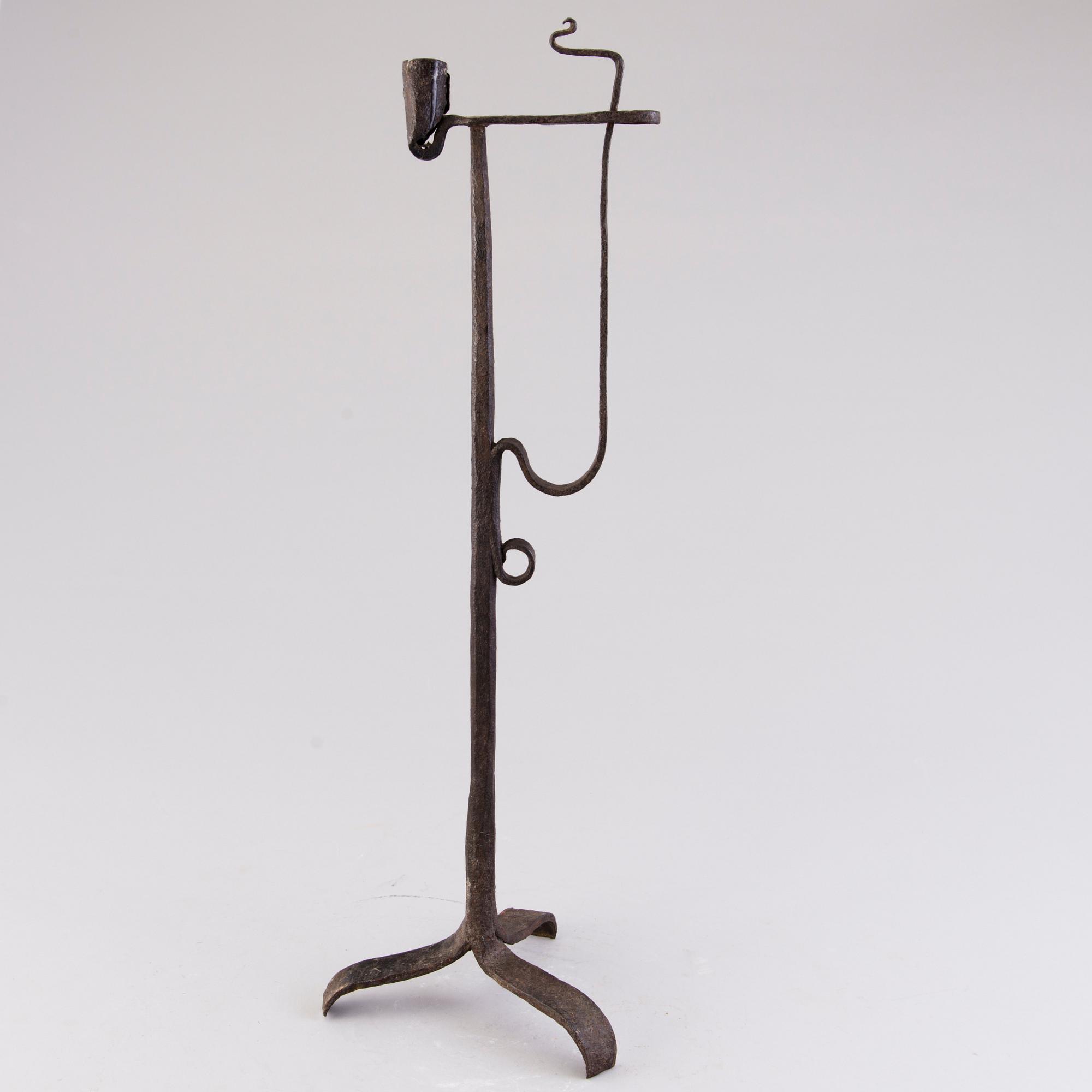 A 18th century wrought iron rush light and candle holder.