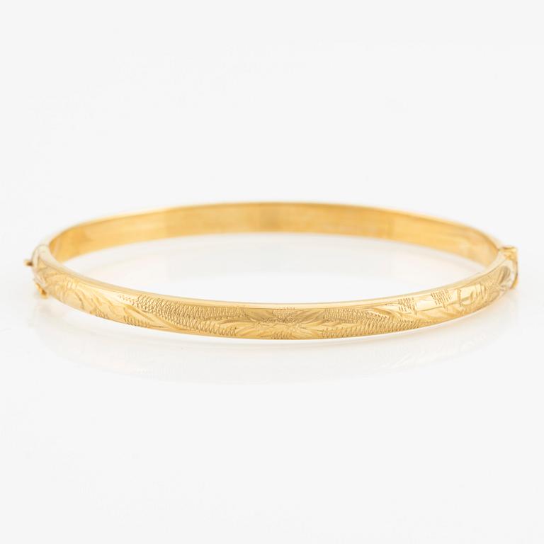 An 18K gold bangle.