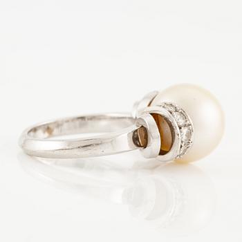 A ring in 18K white gold with a cultured pearl and round brilliant-cut diamonds.