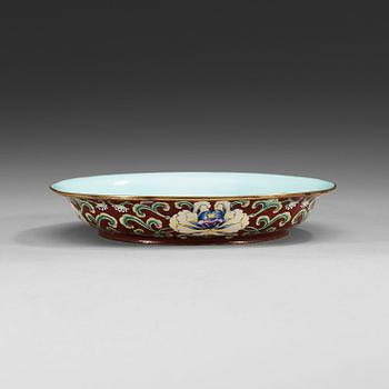 A Canton enamel ruby-red ground dish decorated with lotus flowers, Qianlong seal mark and period (1736-1795).