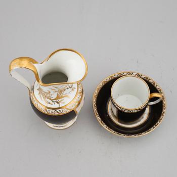 A porcelain jug and a cup with saucer, empire style, circa 1900.