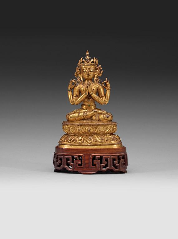 A gilt copper alloy figure of Sukhavati Avalokiteshvara seated on a high lotus base, Tibet, 15th/16th Century.