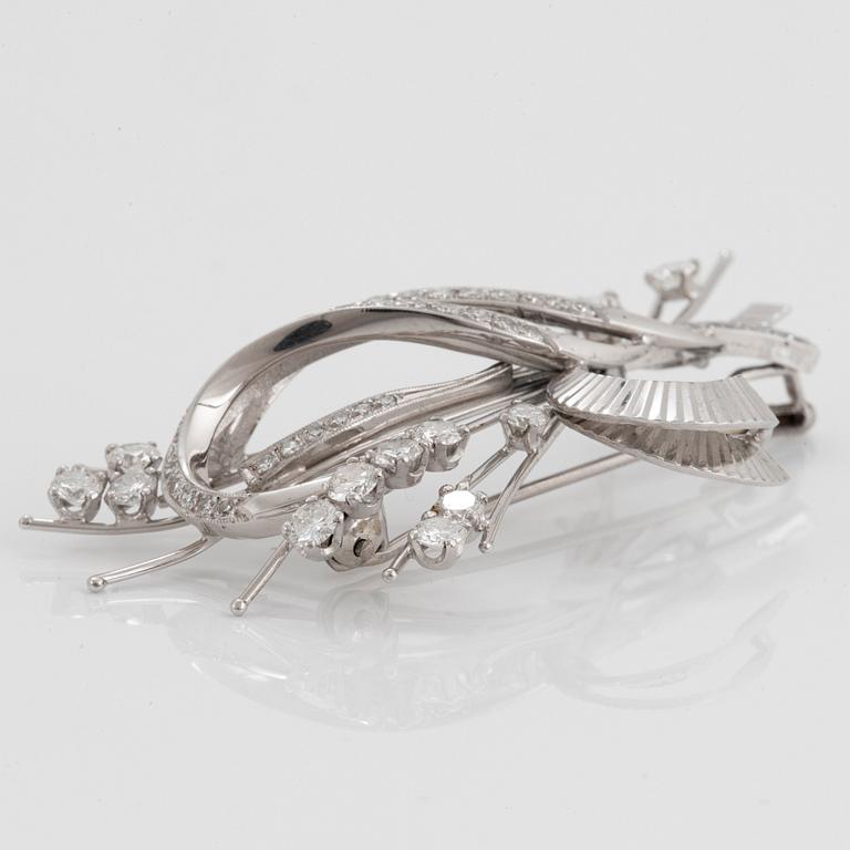 An 18K white gold brooch set with round brilliant- and eight-cut diamonds.