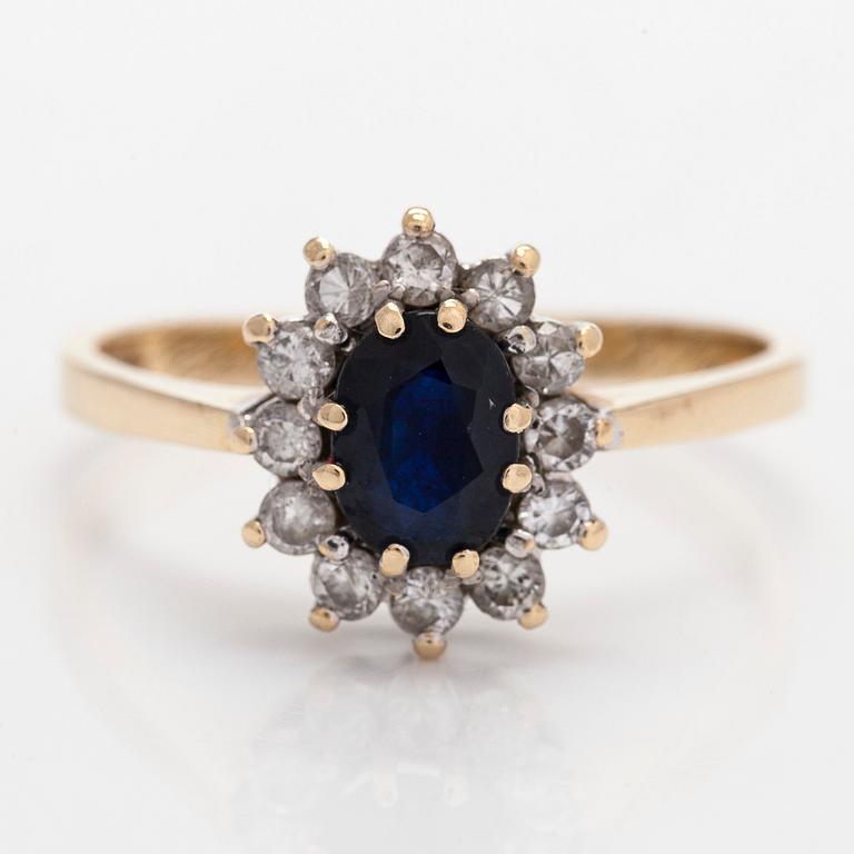 A 14K gold ring, with an oval faceted sapphire and diamonds, England.