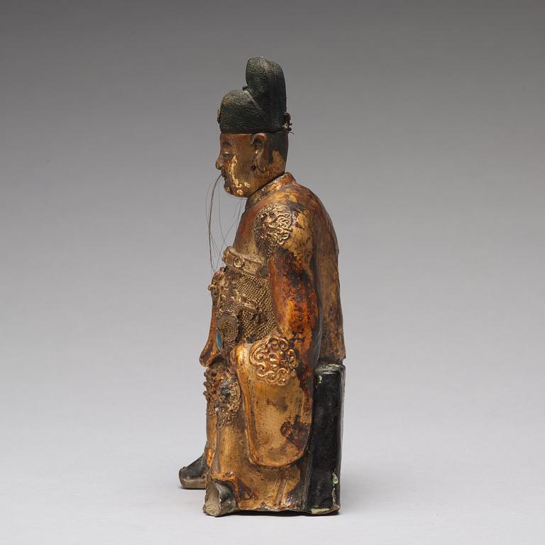 A lacquered and gilt ceramic sculpture of a deity, Ming dynasty (1368-1644).