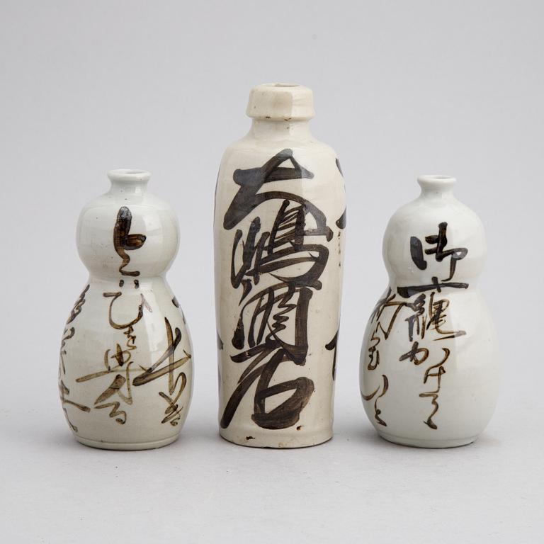 A group of twelve Japanese white glazed ceramic sake bottles, first half of the 20th century and mid 20th century.