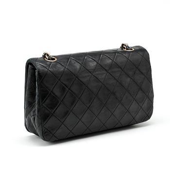 CHANEL, a black leather quilted purse with shoulder strap.