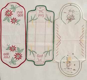 A collection of smaller Christmas tablecloths, runners, and wall hangings, approximately 34 pieces, mid/second half of the 20th century.