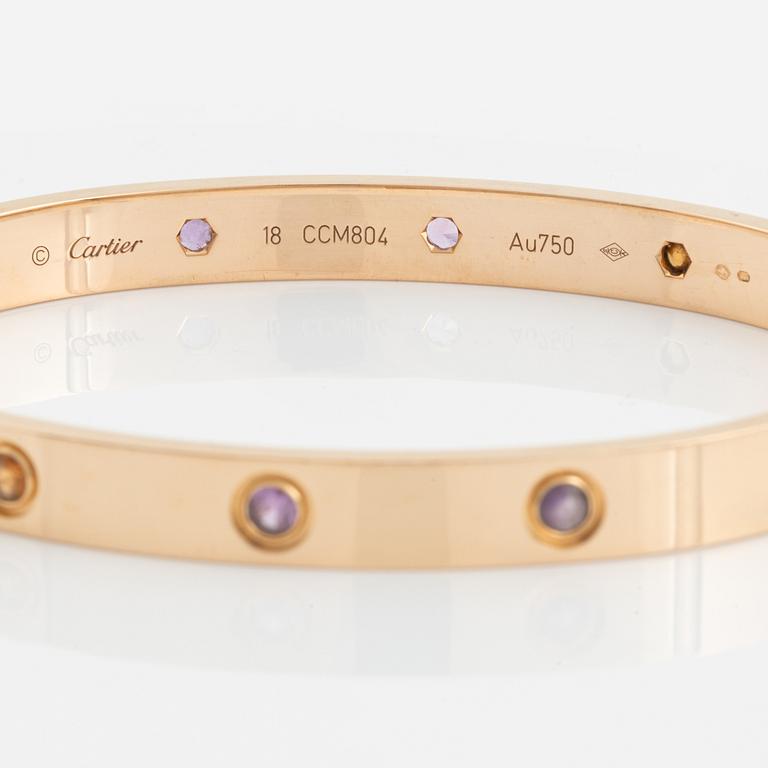 A Cartier "Love" bracelet in 18K rose gold set with colored stones.