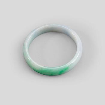 137. A white and green jadeite bangle with traces of lavender colour, China, 20th Century.